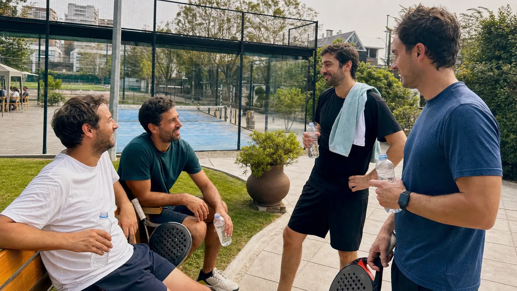 Amigos descansando después de jugar pádel en un club de barrio